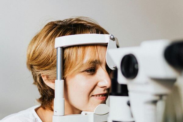 A woman undergoing an eye test using medical equipment, symbolizing what eye care means and why it is important for healthy vision